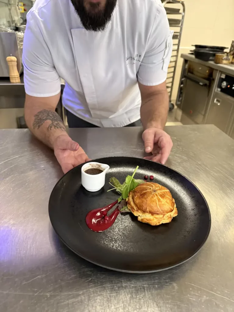 Le chef présente une assiette dans la cuisine du restaurant
